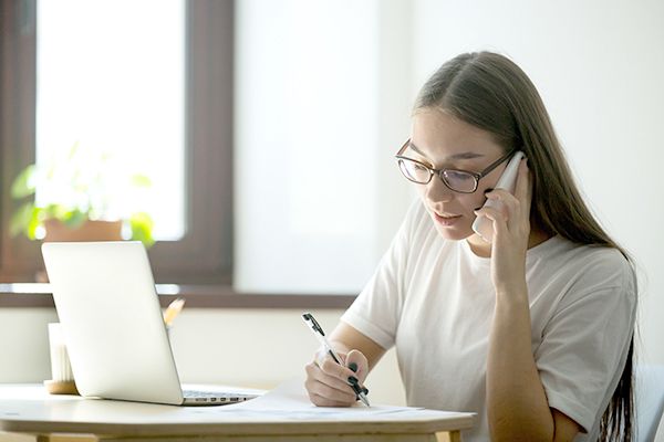 Female worker consulting client over phone